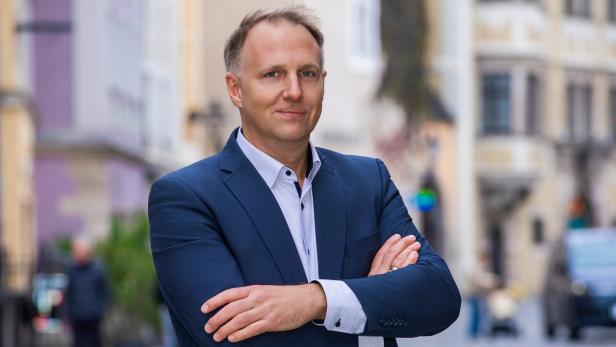 Mann im Anzug mit verschränkten Armen auf einer Straße