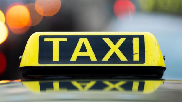 Schild mit Schriftzug auf dem Dach eines Wiener Taxis.