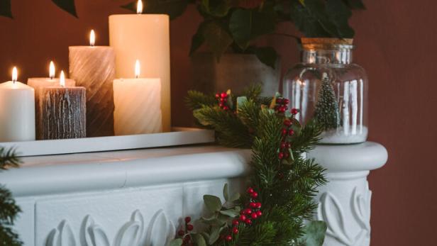 Ein mit Kerzen geschmückter, weinachtlicher Kamin.