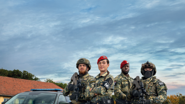 Soldaten in Uniform vor einem Auto 