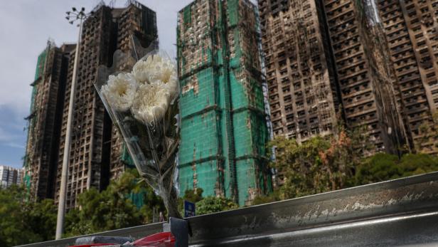 Flower bouquet is placed at the scene of the Wang Fuk Court housing estate fire as mourners pay tribute to the victims, in Tai Po, Hong Kong,
