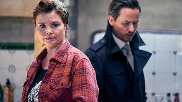 Annette Frier steht neben einem Mann im Mantel.