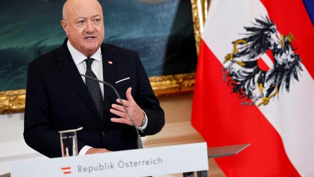 Christian Stocker spricht am Rednerpult mit der Aufschrift "Republik Österreich", neben der österreichischen Flagge.