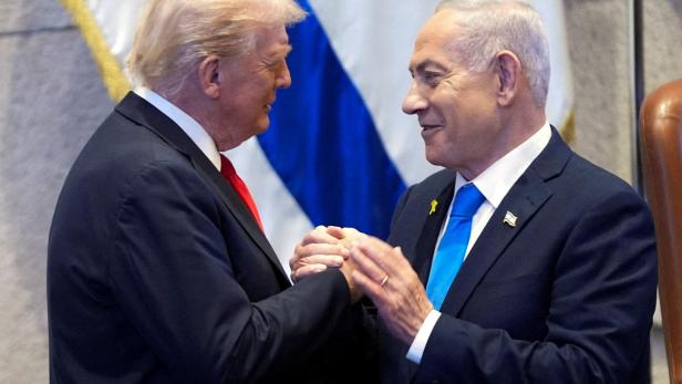 Donald Trump und Benjamin Netanjahu geben sich vor einer israelischen Flagge die Hand.