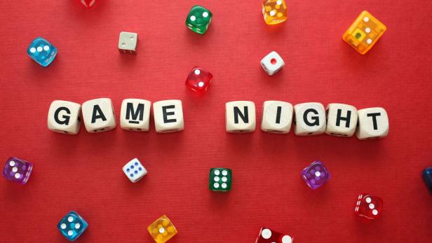 Wooden word dice spell 'Game Night' with multicoloured dice around it.
