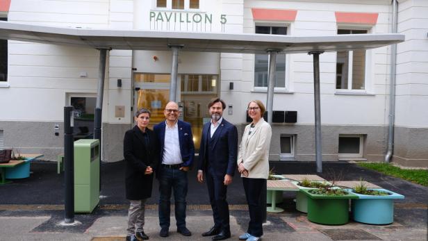 Vier Personen stehen vor Gebäude 