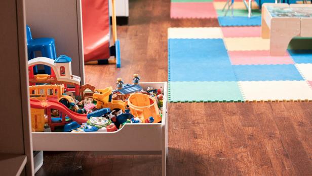 Ein leerer Indoor-Spielbereich mit bunten Matten und Spielzeug.