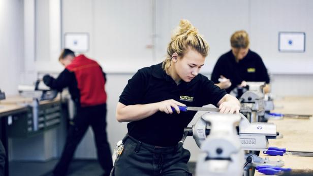 Eine Frau arbeitet an einem Werktisch.