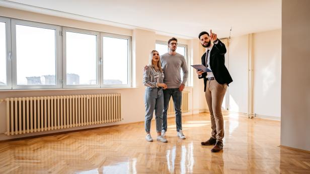 Real estate agent showing an apartment for sale to a young couple