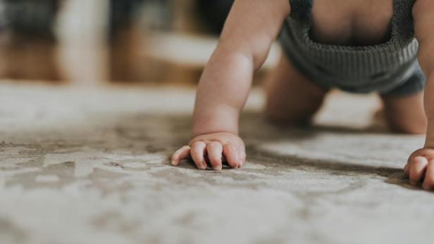 Baby krabbelt über den Boden
