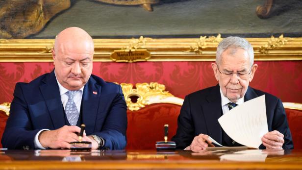 Christian Stocker und Alexander Van der Bellen sitzen an einem Tisch vor einem Gemälde.