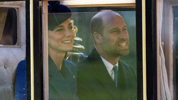 Kate und William lächeln aus dem Fenster einer Kutsche.