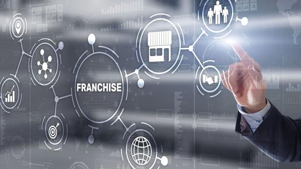 Businessman hand touching inscription Franchise marketing system.