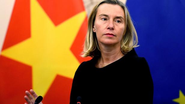 Mogherini steht vor den Flaggen Vietnams und der Europäischen Union und spricht an einem Mikrofon.