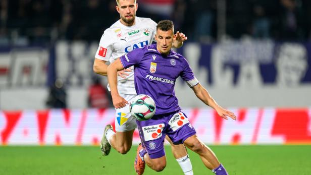 Ein Austrianer und ein Spieler von WSG Tirol kämpfen um den Ball.