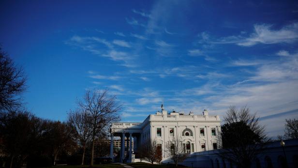 The setting sun illuminates the White House in Washington