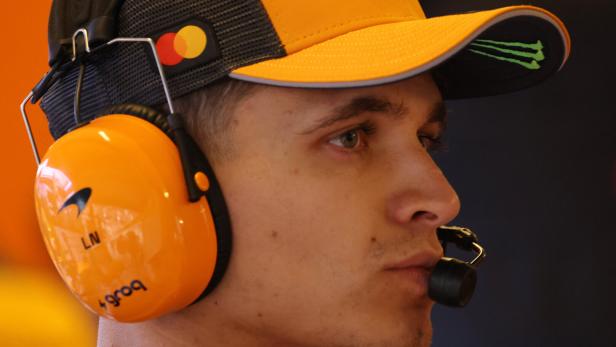 Lando Norris trägt McLaren-Kopfhörer.
