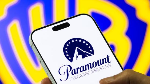 Paramount Skydance Logo auf Handy - im Hintergrund das Warner Bros Logo