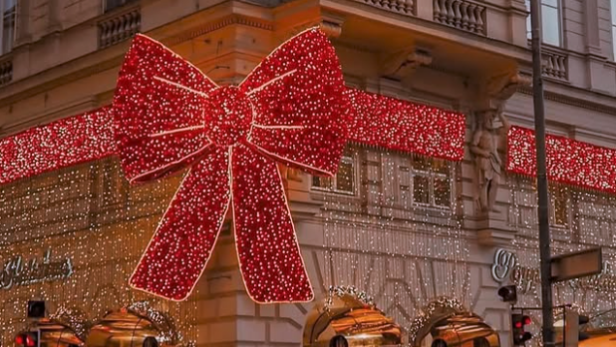 Riesige rote Weihnachtsschleife mit Lichterketten an einem Eckhaus auf der Kärntner Straße.