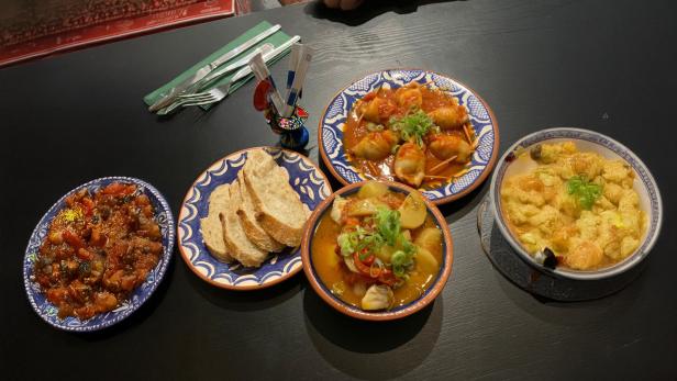Teller mit Essen auf einem schwarzen Tisch 