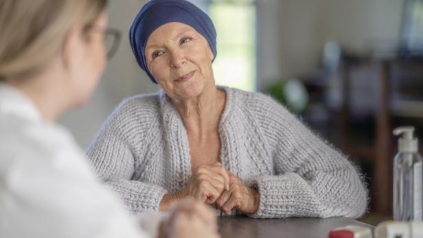 Eine Frau mit Kopftuch sitzt mit einer Ärztin an einem Tisch.