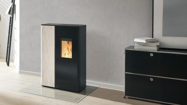 Moderner Pelletofen mit sichtbarer Flamme in einem stilvoll eingerichteten Wohnzimmer.