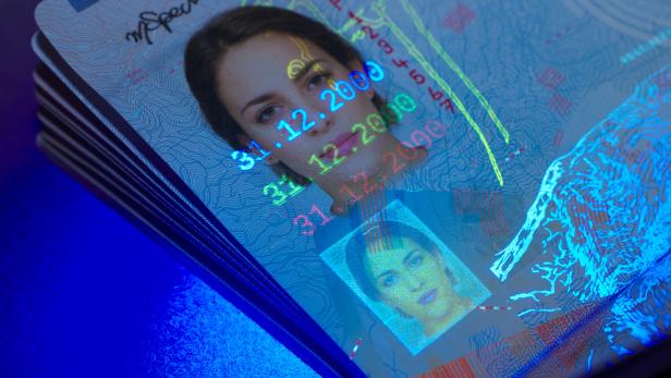 Der Ausweis einer Frau unter einem Blaulichtfilter. 