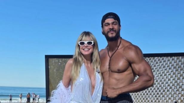 Eine Frau in einem durchsichtigen weißen Kleid mit einem muskulösen Mann ohne T-Shirt