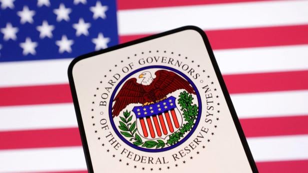 Illustration shows United States Federal Reserve System logo and U.S. flag