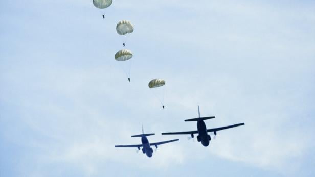 Row of parachutists and two airplanes