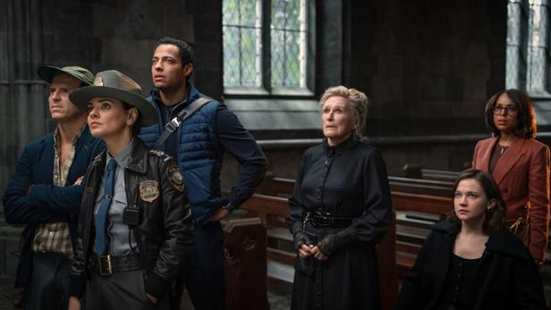 Eine Gruppe von Gemeindemitgliedern steht vor den Kirchenbänken