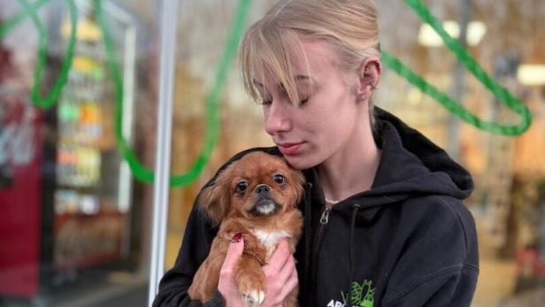 Eine Frau hält einen Welpen im Arm