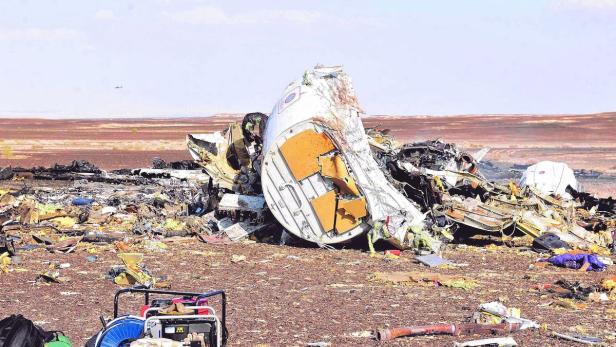 Die Trümmer eines Flugzeugs liegen in einer Wüstenlandschaft verstreut.