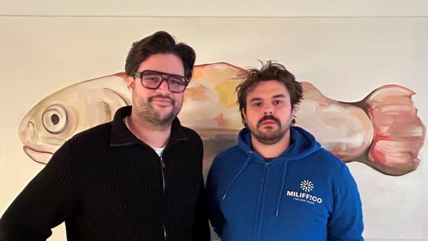 Simon Schubert und Julian Lechner stehen vor einem Fischbild. 