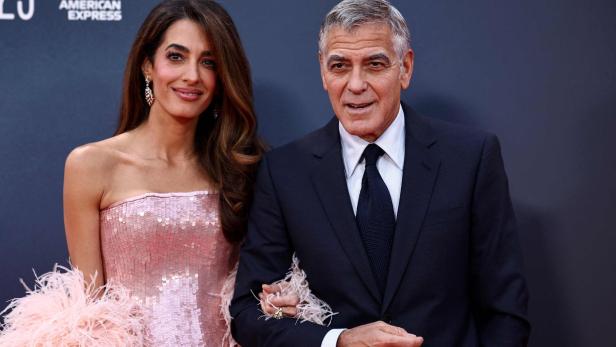 Amal und George Clooney schön gekleidet bei einem Event.