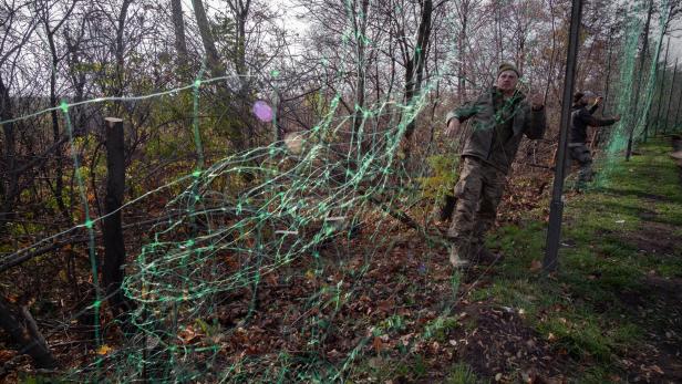 Soldaten des 11. ukrainischen Armeekorps installieren im Gebiet Donezk Anti-Drohnen-Netze entlang einer Frontstraße – als Schutz vor russischen FPV-Angriffsdrohnen. 