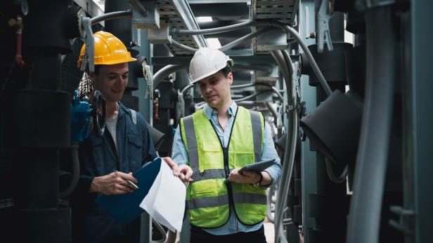 Engineer and team examining the air conditioning cooling system of a huge building or industrial site.