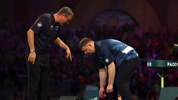 Ein Mann beugt sich mit blutender Hand nach unten, während ein Schiedsrichter auf den Boden zeigt.