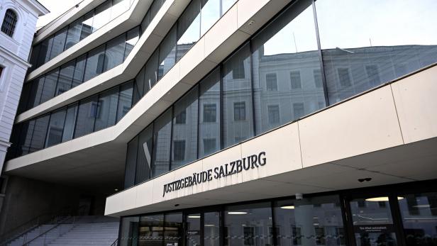 Das Justizgebäude Salzburg mit seiner modernen Glasfassade und dem Schriftzug ist zu sehen.