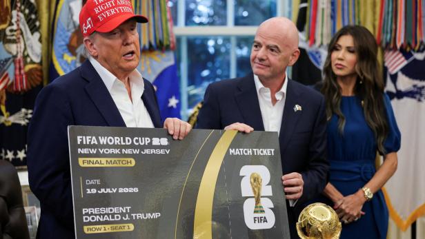 Donald Trump hält Gianni Infantino ein Plakat in die Kameras.