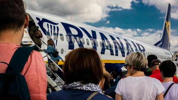 Mehrere Passagiere warten darauf, in ein Ryanair-Flugzeug einzusteigen
