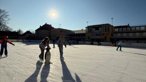Menschen auf einem Eislaufplatz.
