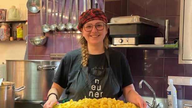 Svenja Knisel mit einem Blech gefüllt mit geschälten Kartoffeln.