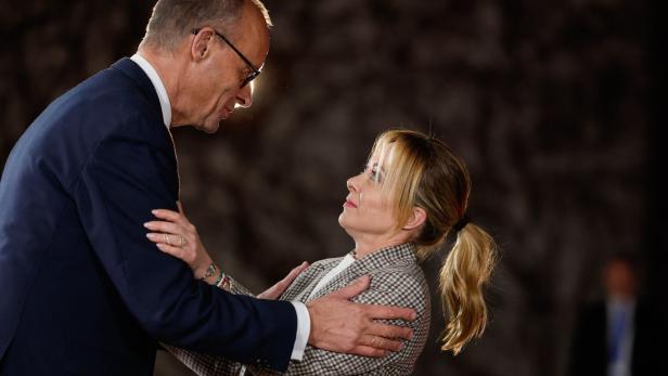 Friedrich Merz legt Giorgia Meloni die Hände auf die Schultern.