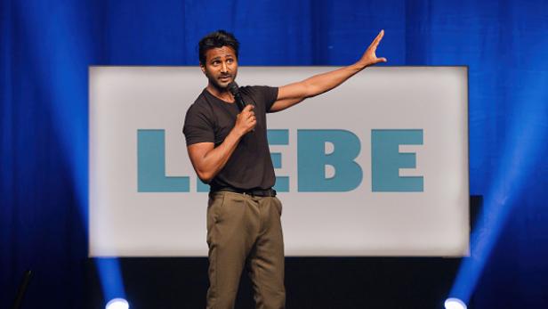 Kattilathu auf der Bühne mit Mikrofon