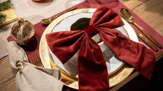 Rote Samtschleife auf gedecktem Tisch