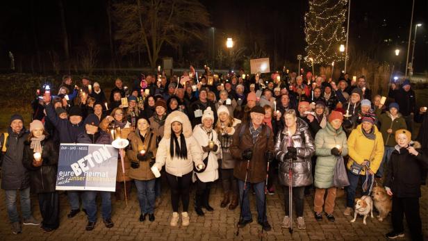 Eine Menschenmenge steht auf einer Wiese.