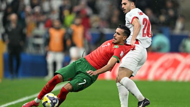 Ein Spieler von Jordanien hält einen Spieler vom Marokko am Trikot.