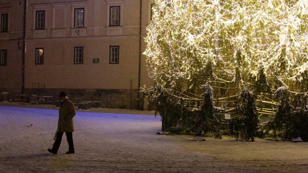 Mann und Weihnachtsbaum auf einem Platz