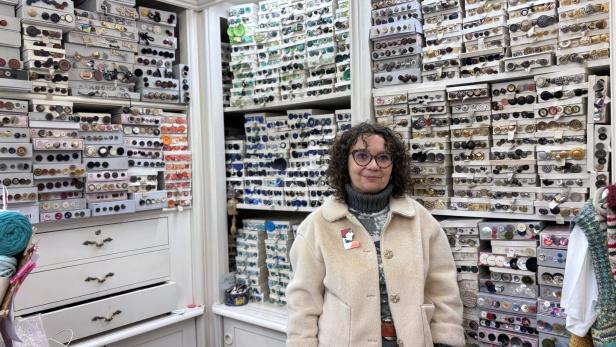 Martina Schrutka steht in ihrem Geschäft vor einer Wand voller Knöpfe.